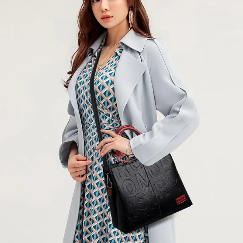black crossbody handbag in pu leather featuring embossed toms logo and red handle accents in style1 style2 design