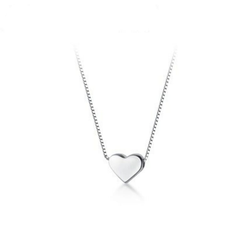 un colgante de corazón minimalista de plata, elegante, que cuelga de un delicado collar de cadena tipo eslabones de papel en plata de ley