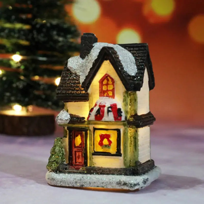 Maison miniature du village de Noël à LED, avec un toit en ardoises noires, des détails blanchis par la neige en blanc, et un éclairage intérieur jaune chaud, veilleuse à batterie.
