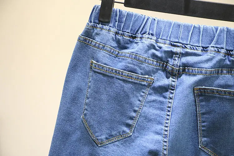 Jeans en denim bleu clair extensible taille haute avec taille élastique et deux poches arrière, présentés depuis la face arrière