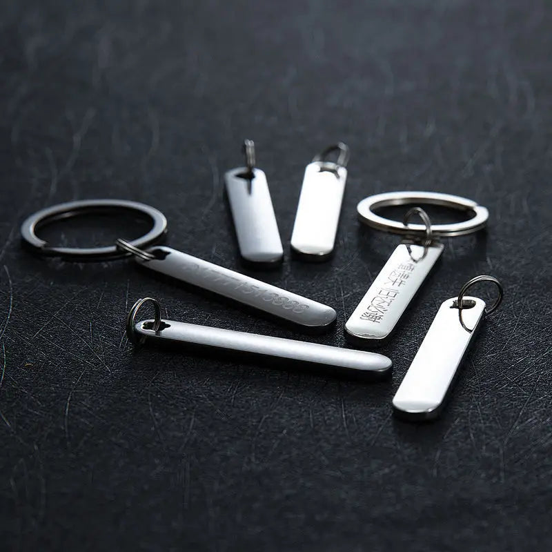 Silver rectangular custom phone number keychains with laser engraved text and a polished metallic finish.