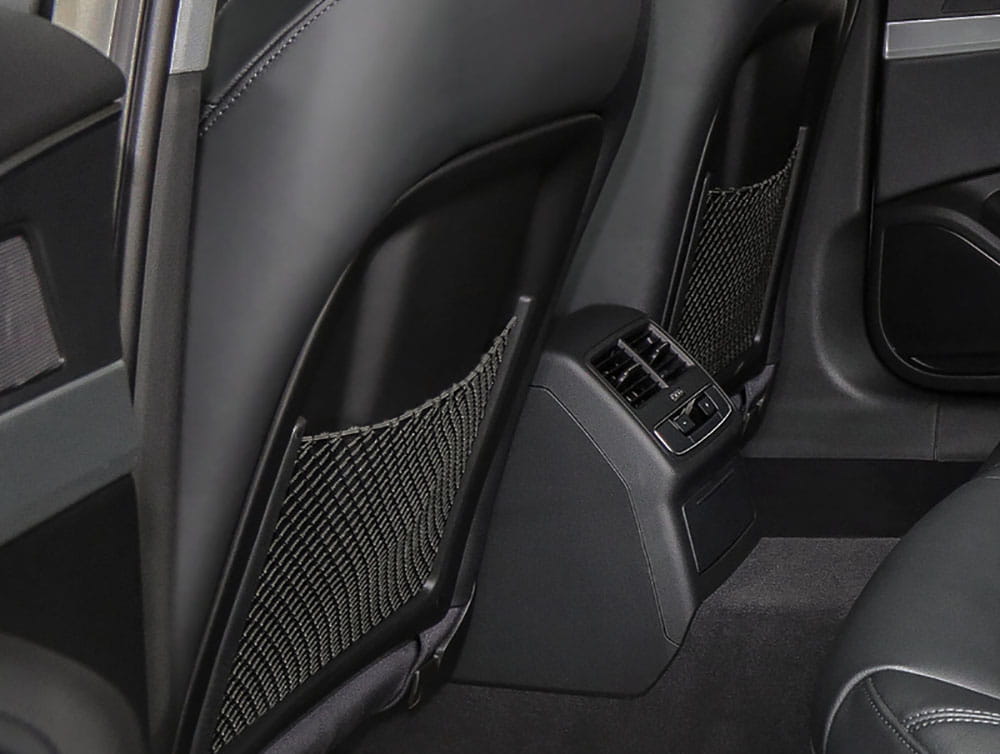 Parte posterior de un asiento Audi de cuero negro que muestra detalles cosidos y un bolsillo organizador de malla.