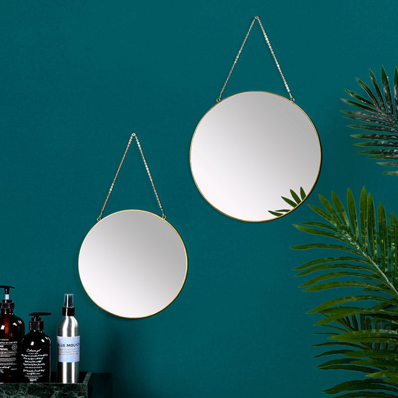 Two round hanging mirrors with gold-toned frames and silver chain suspensions complement the gold hexagonal wall hanging mirror collection.