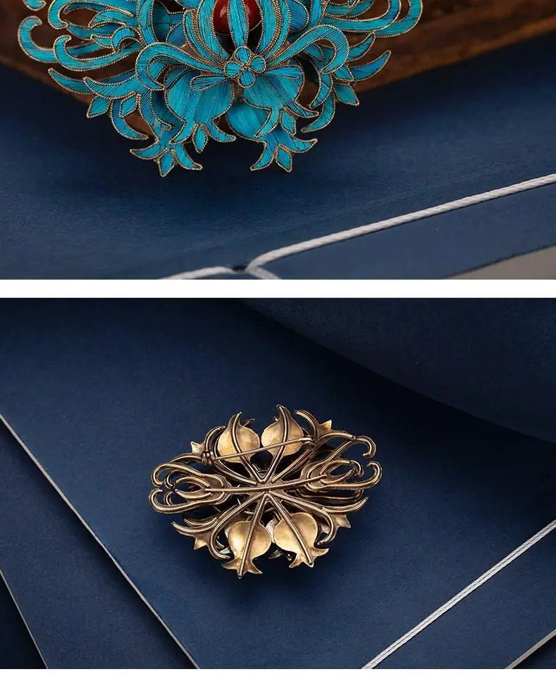 A turquoise and gold filigree brooch featuring intricate floral detailing from palace jewelry.