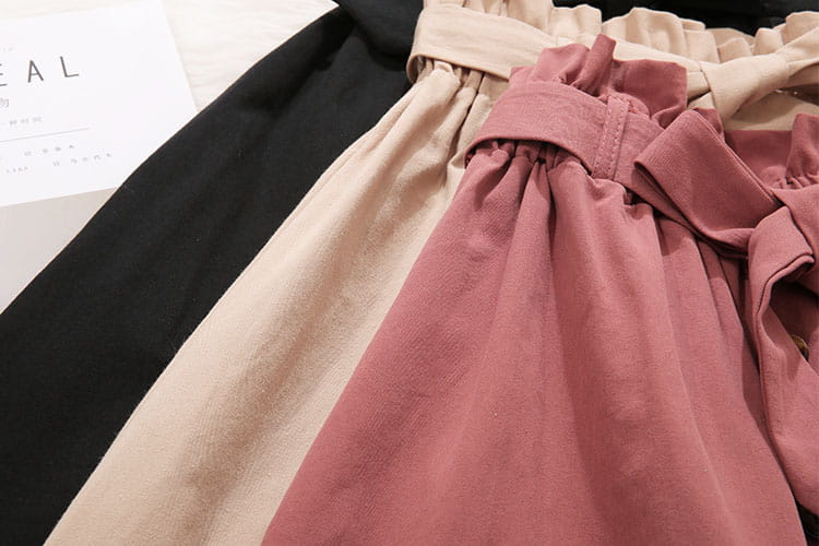 La jupe midi en coton à taille haute, robe décontractée en ligne A, se porte avec un pantalon taille haute beige rosé clair et noir, avec des ceintures élastiques et des détails de tissu froncé.