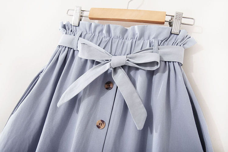 Jupe midi en coton bleu clair, taille haute, robe décontractée en ligne A, avec un nœud en satin assorti à la taille et deux boutons ton or sur le devant.