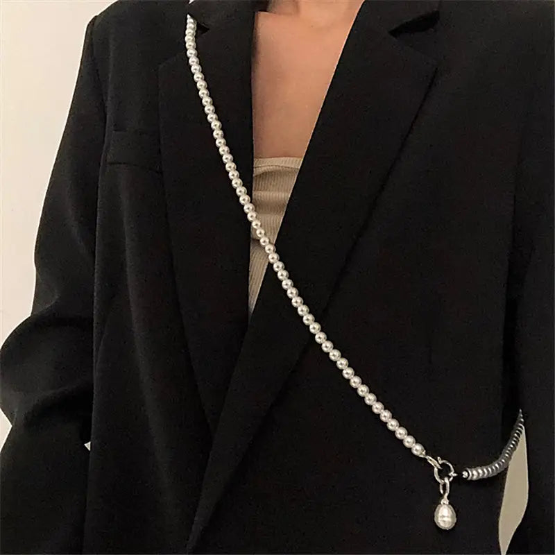 Un collier délicat en forme de goutte de perle au ton argenté, présentant des perles sphériques espacées de manière régulière et un accent métallique enroulé près de la fermeture.