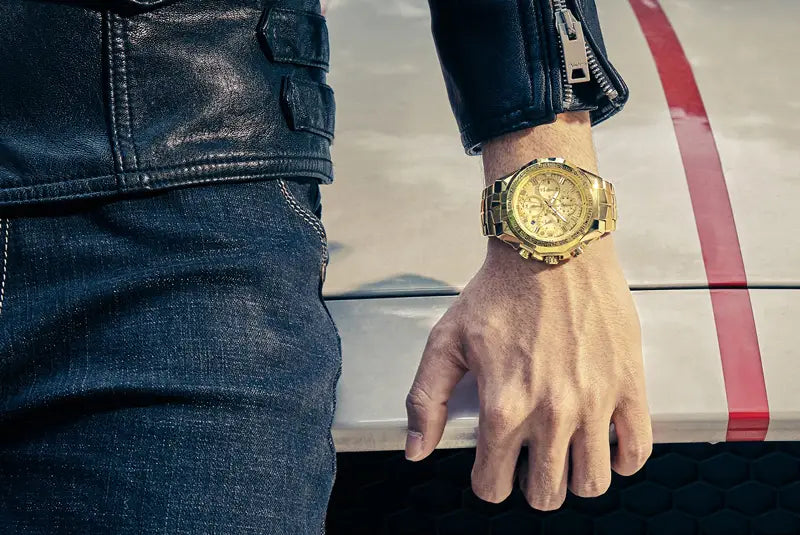 Gold-tone chronograph watch with a stainless steel metallic bracelet worn on a wrist showcasing a luxury timepiece for men.