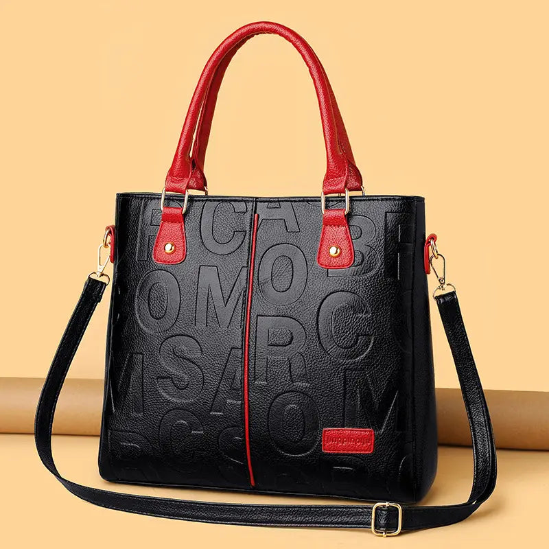black crossbody handbag style1 style2 in black pu leather with red handles and matching adjustable strap featuring embossed lettering across the front