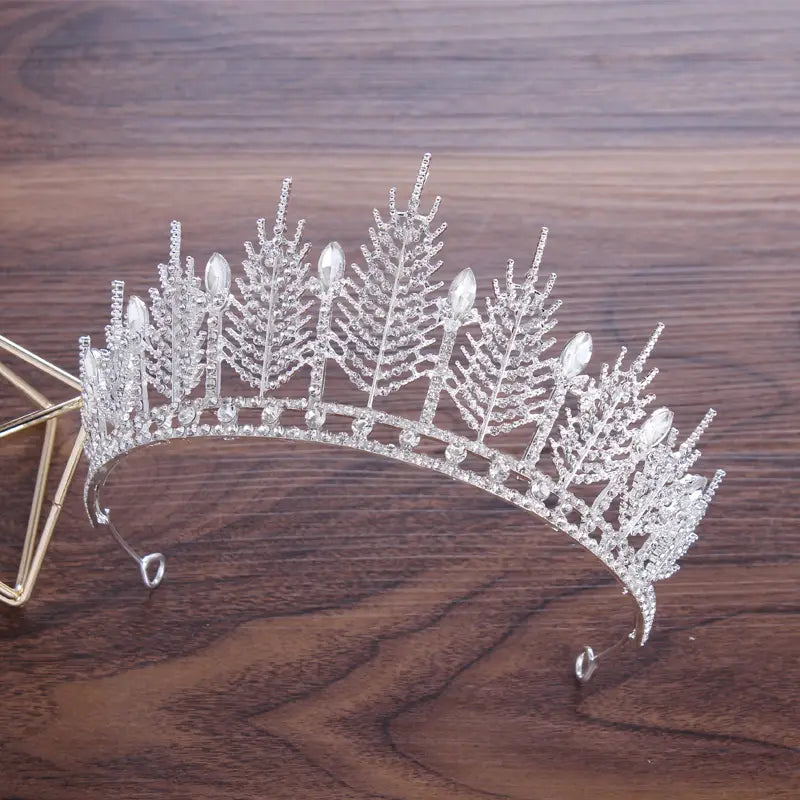 Silver crystal bridal tiara featuring intricate fern-like designs and sparkling clear crystals for a wedding crown headpiece.