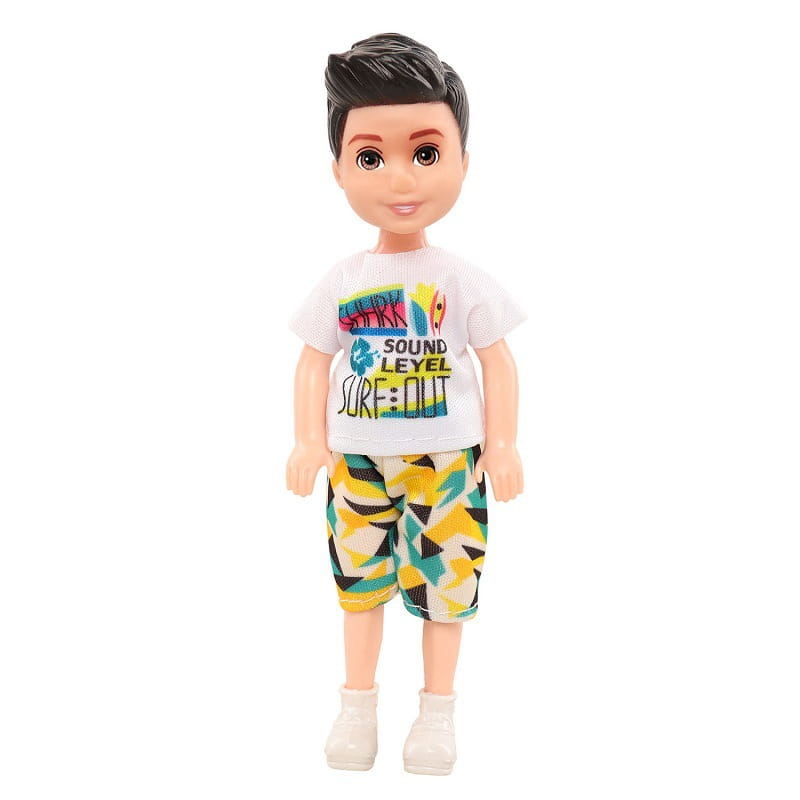 Eine Jungenpuppe mit schwarzem Haar, die ein weißes T-Shirt mit bunten Surf-motivierten Grafiken und Shorts mit gelb, türkis und schwarzen Mustern aus dem Puppenkleidungs-Set mit 6-teiligen Modebekleidungszubehörteilen trägt.