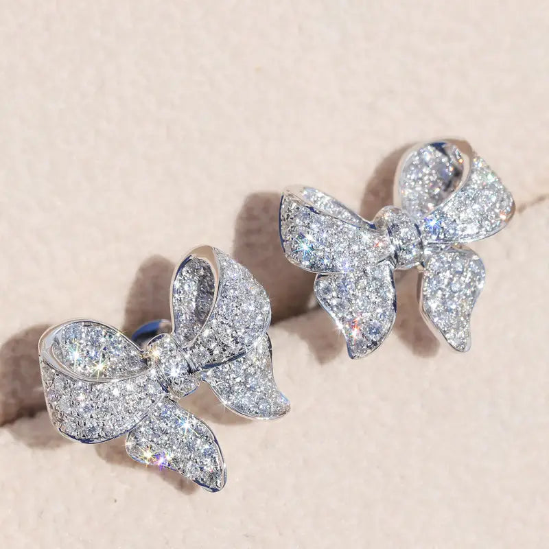 Silver bowknot zircon necklace and earrings set featuring sparkling diamond-encrusted bow-shaped stud earrings in a sleek silver setting.