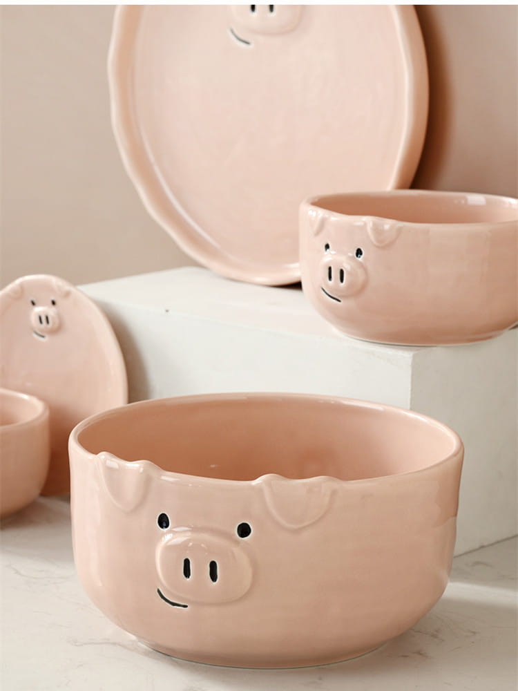 Pink ceramic bowl with a smiling pig face design from the cute pig ceramic dinnerware set.
