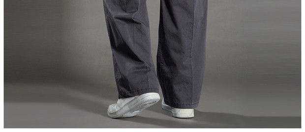 Dark gray cotton men cargo pants with a relaxed fit and subtle stitching details designed as utility trousers.