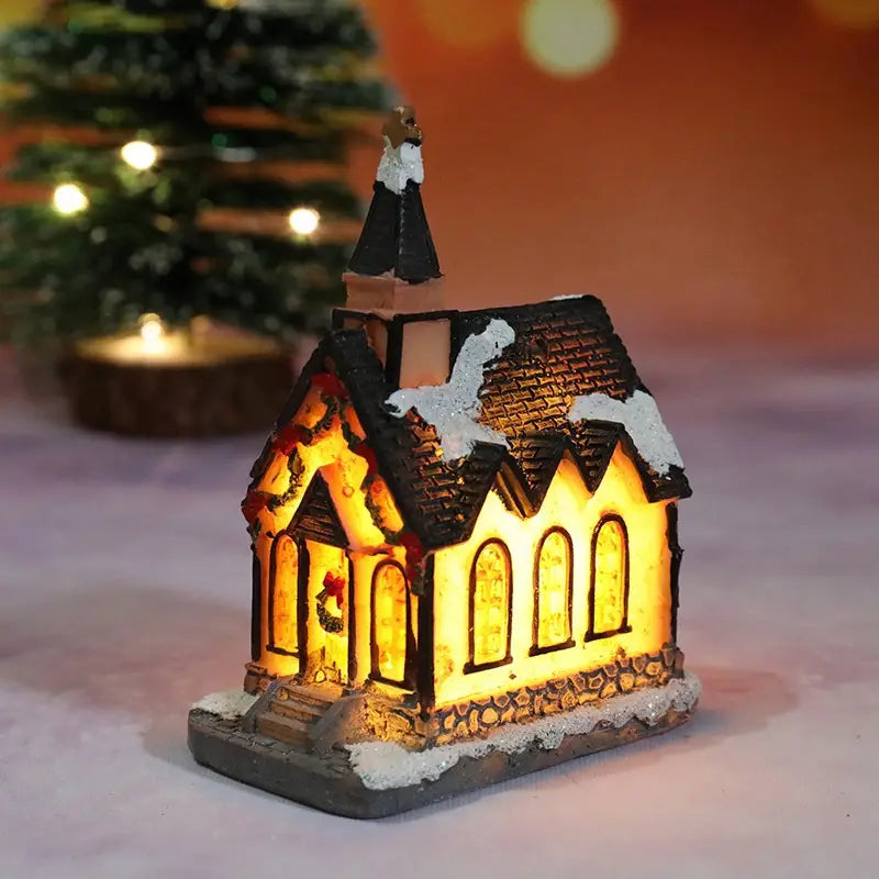Une figurine miniature de l’église de Noël du village, illuminée, avec un toit noir et des détails blanchis par la neige, offrant un éclairage intérieur jaune chaud, pour un ensemble de maisons de village de Noël à LED, veilleuse à batterie.