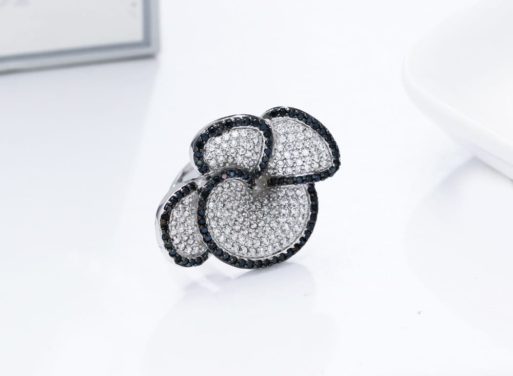 A sparkling black and white crystal statement flower ring with a pave diamond setting.