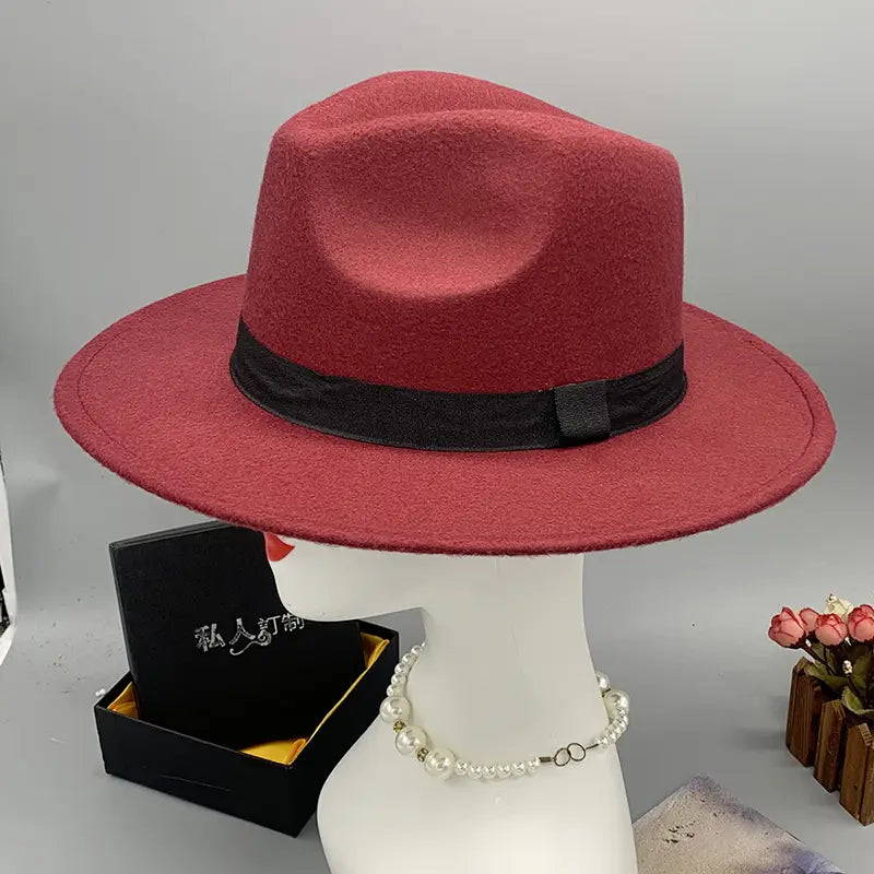 A rich burgundy unisex woolen felt fedora hat featuring a sleek black ribbon band and a feather accent.