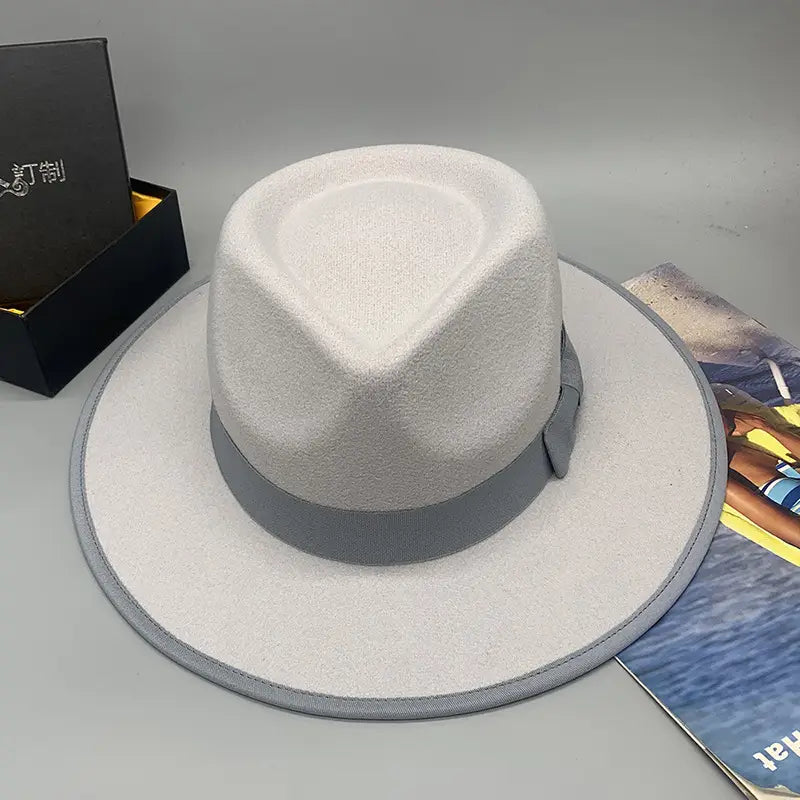 A light gray unisex woolen felt fedora hat with a wide brim and a dark gray ribbon band featuring a feather accent.