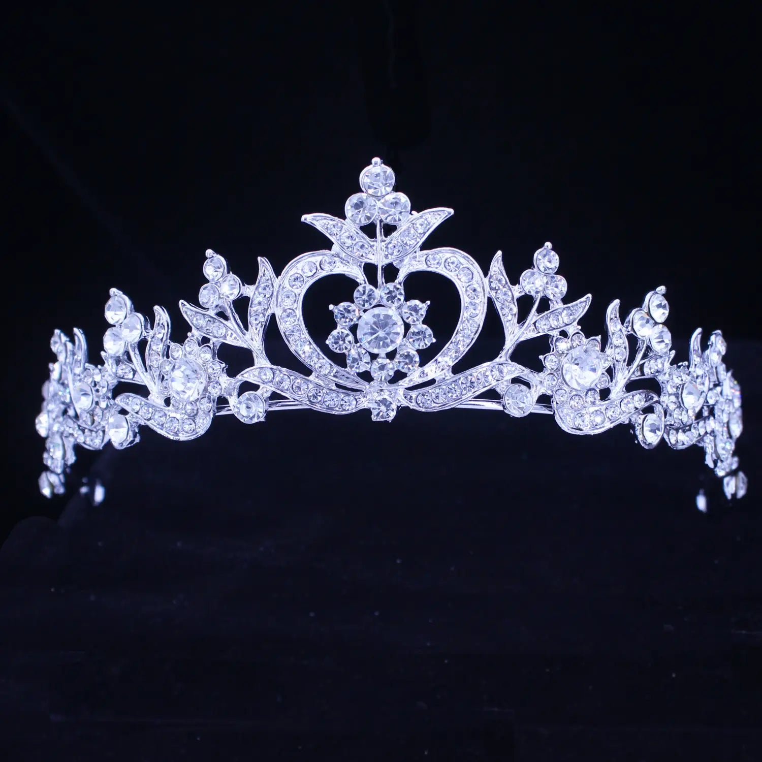 Una diadema de boda floral con tiara de novia de cristal en plata brillante, adornada con diseños florales intrincados y cristales transparentes, con un motivo central con forma de corazón.