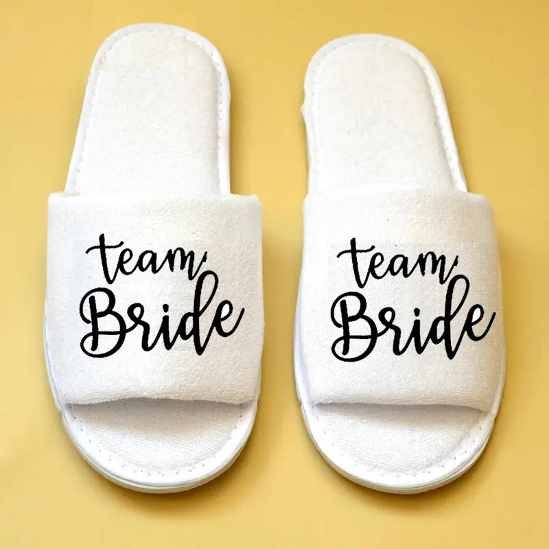 Weiße flauschige durchgehende Schlupf-Brautparty-Slipper mit „Team Braut“ in schwarzer, geschwungener Handschrift für Braut- und Bräutigam-Hochzeits-Slipper.
