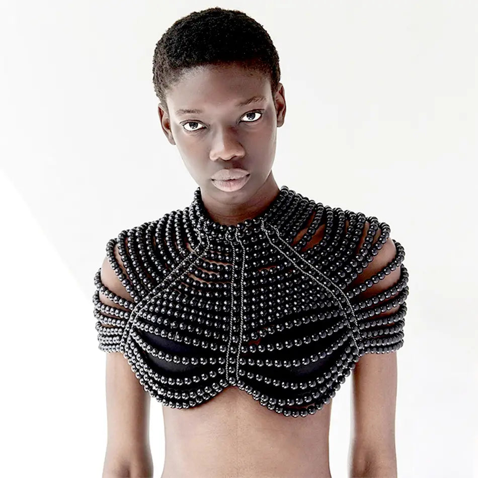 Pièce d’épaule en perles noires, avec un design superposé structuré, présentée dans un collier de mode en chaîne corporelle de perles.