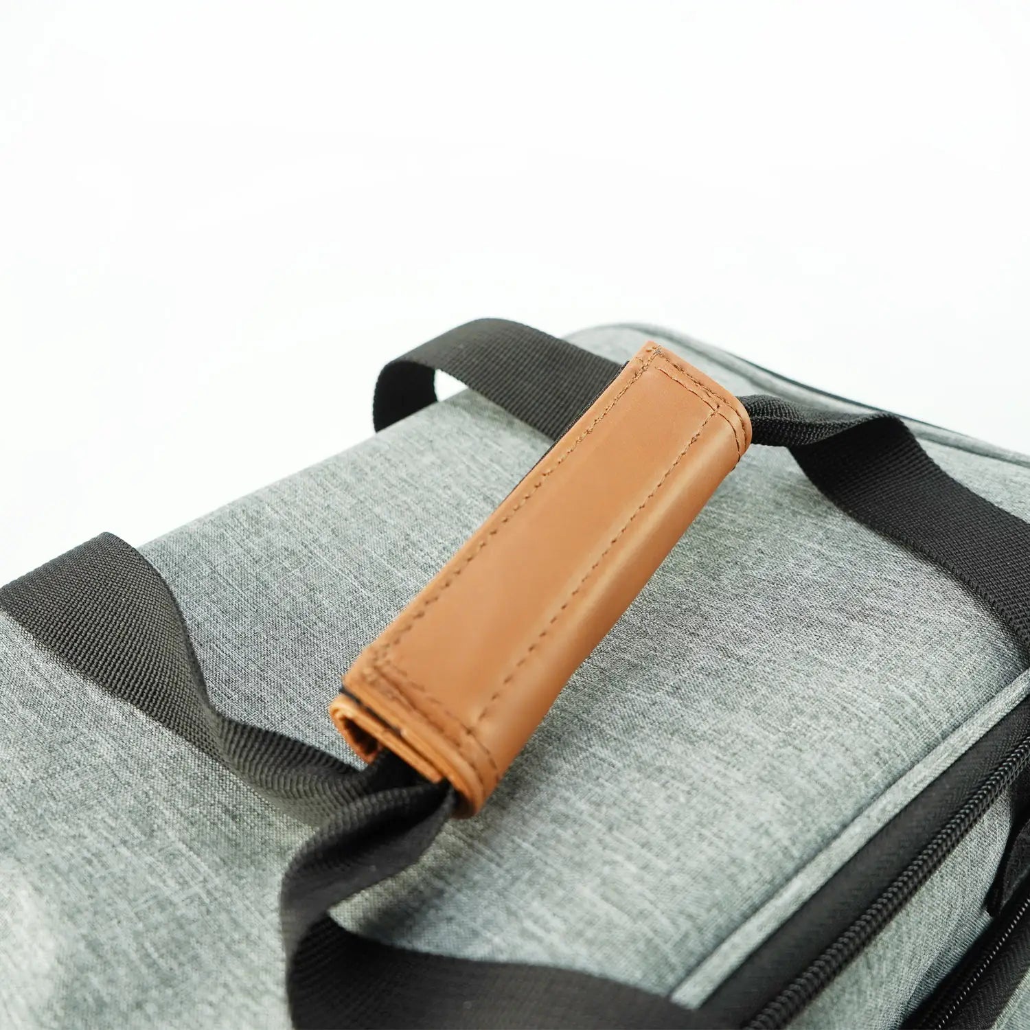 Organisateur de sac à dos de voyage pour chien en tissu texturé gris, avec sangles noires et poignée en cuir beige, conçu comme sac de voyage pour l’animal et approuvé pour le transport aérien.