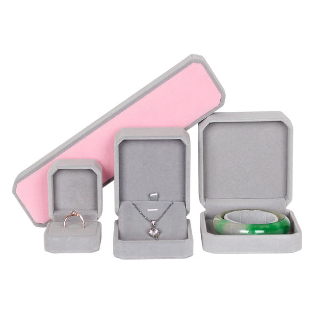 graue Samt-Schmuckschachteln mit rosa Innenfutter, jeweils eine Schachtel, in der Ohrringe mit Gold-Drachenring als feines Schmuck-Geschenk aufbewahrt werden