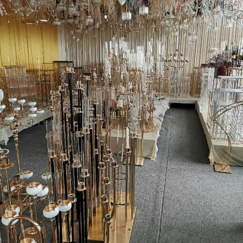porte-bougies métalliques dorés et noirs avec des tubes en verre transparents pour servir de support de fond d’arche de mariage dorée pour des réceptions