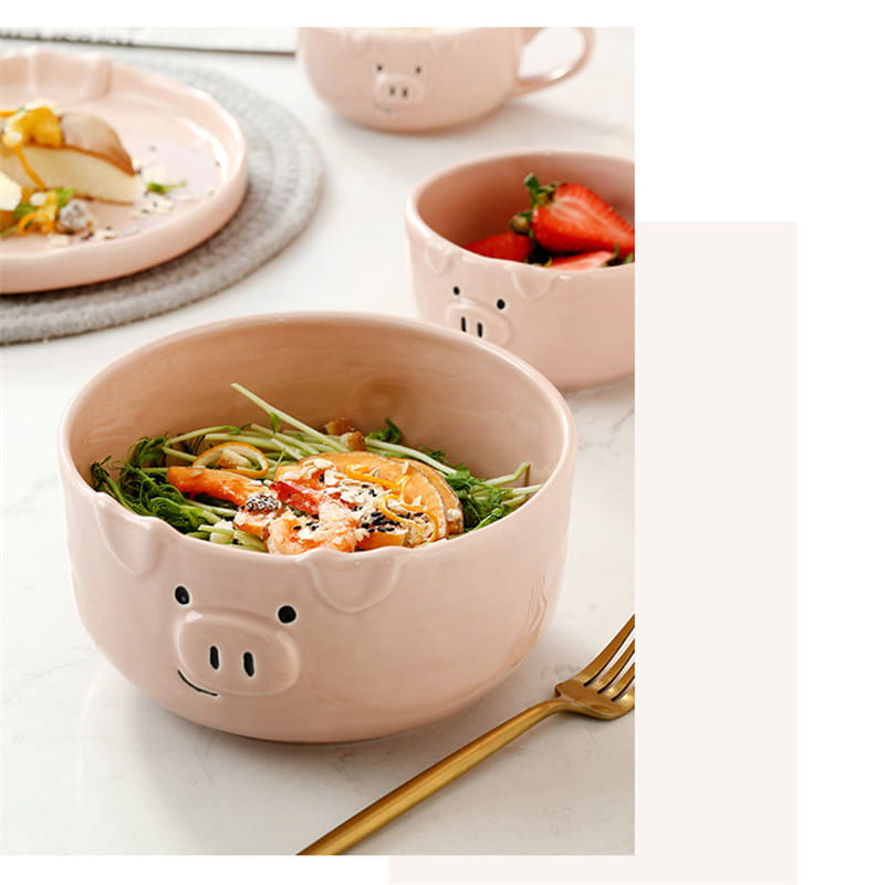 Pink ceramic pig-shaped bowl with a smiling face and black dot eyes from the cute pig ceramic dinnerware set.