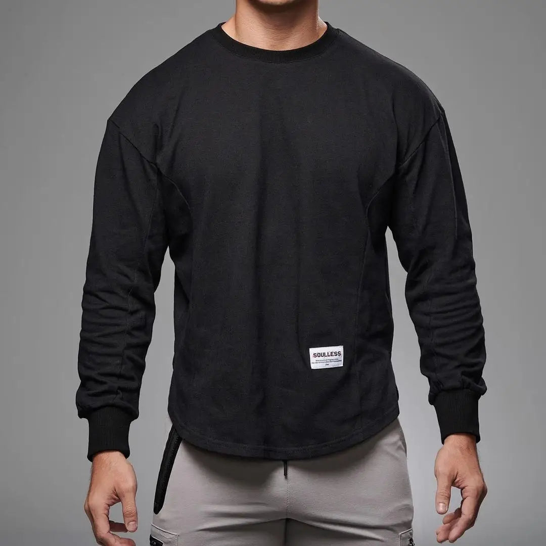 Black men long sleeve cotton t shirt with crewneck, curved hem, subtle seam detailing, and white label on the lower front.