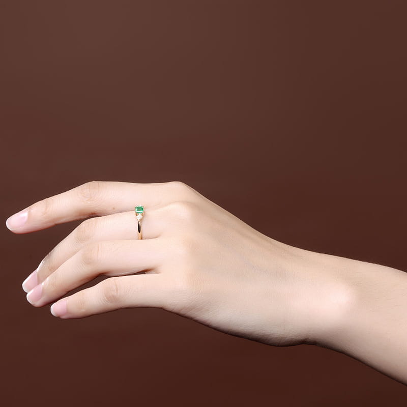 Verlobungsring aus 18k Gold mit Smaragd und Diamanten mit einem zarten rechteckigen Smaragdstein, gesetzt in einem eleganten, minimalistischen Design.
