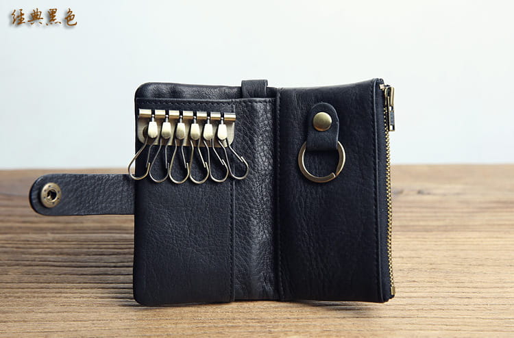 Black leather key chain wallet for men with brass-colored metal hardware and zipper closure.