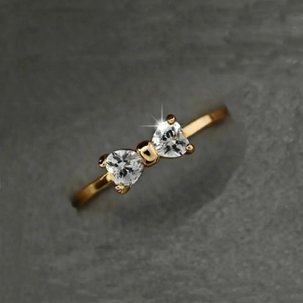 Bague de mariage en nœud en argent sterling en oxyde de zirconium cubique, de ton or, présentant deux diamants clairs en forme de cœur étincelants dans un design délicat de nœud.