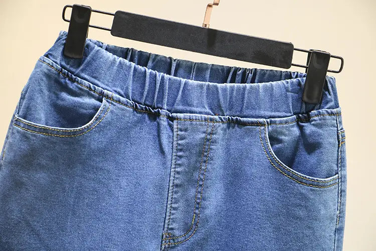 Jupe en denim bleu clair extensible taille haute, avec taille élastique et poches à l’avant, fabriquée à partir de matière en denim bleu clair.