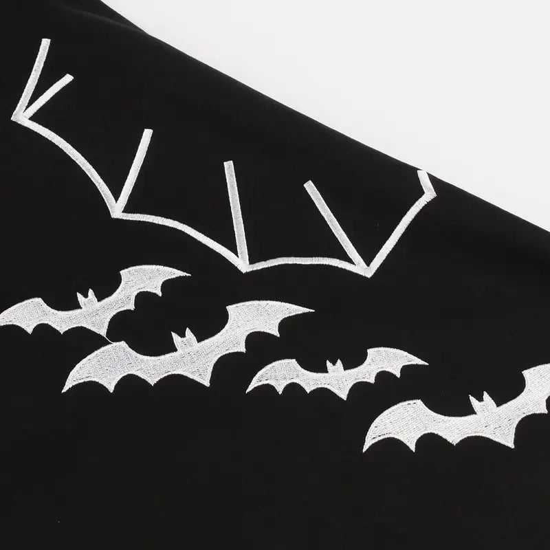 schwarzes Vintage-A-Linien-Kleid mit weißer Bat-Embroiderie im Flug auf einem Baumwollmischgewebe, von vorn betrachtet