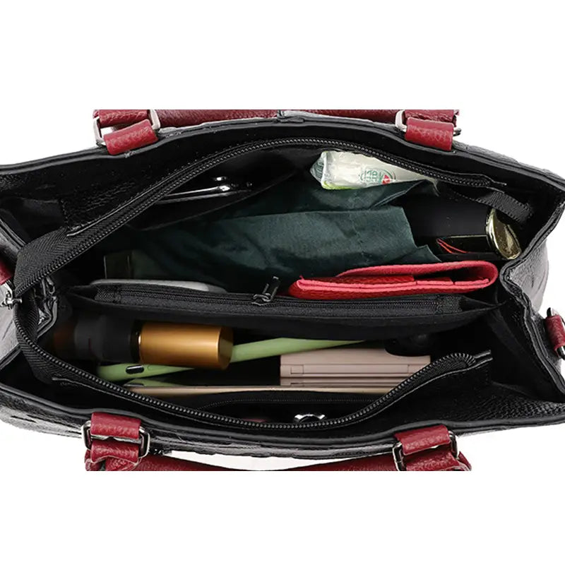 Black textured handbag with red leather handles and trim made of pu leather in satchel style1 style2 suitable as a crossbody handbag.