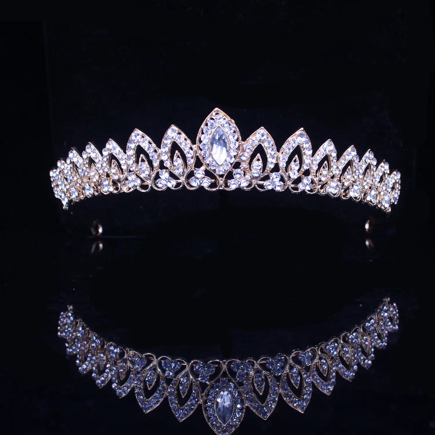 Una tiara de novia de cristal rosa dorado brillante, con patrones intrincados con forma de hojas y un cristal central en talla marquesa rodeado de cristales transparentes más pequeños, para uso en bodas.