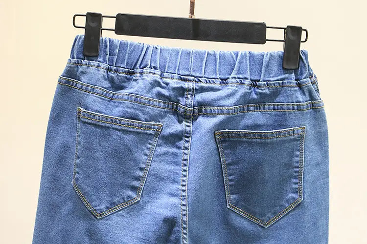 Vue arrière d’une jupe en denim bleu clair extensible taille haute, avec taille élastique et deux poches arrière, fabriquée dans une matière en denim bleu