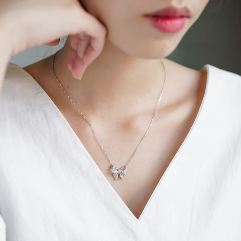 A delicate silver bowknot zircon necklace featuring a sparkling bow pendant adorned with numerous clear crystals.