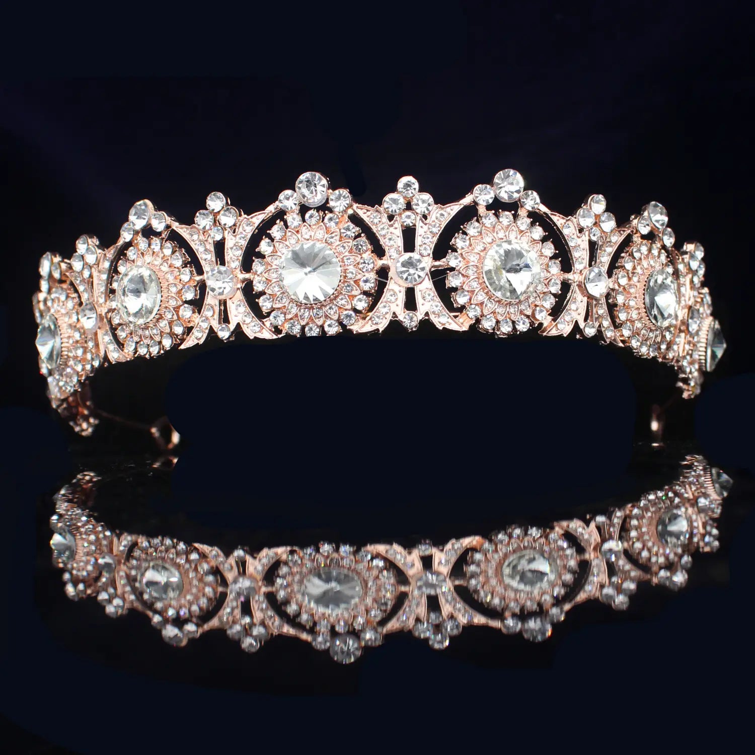 Una tiara de novia de cristal rosa dorado con filigrana intrincada y cristales transparentes brillantes, diseñada como diadema de boda floral.