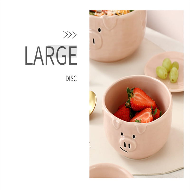 Pink ceramic pig-shaped bowl from the cute pig ceramic dinnerware set filled with sliced strawberries.