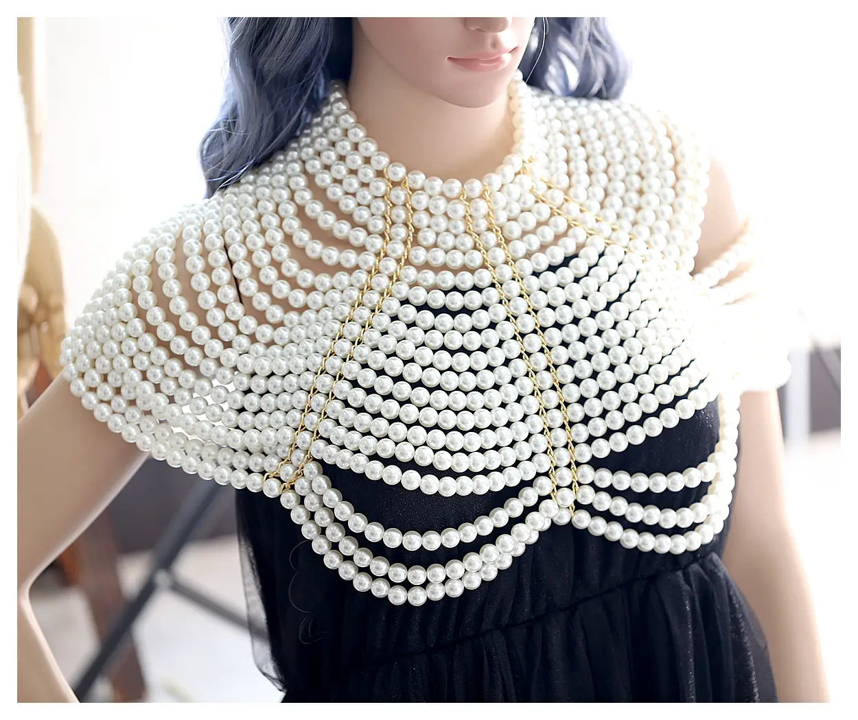 Collier de mode en chaîne corporelle de perles comportant un col en perles blanches, avec des rangées superposées de brins ondulants, maintenus ensemble par de délicates chaînes au ton doré.