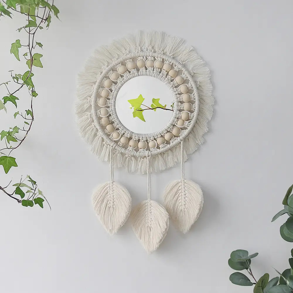 Cream-colored macrame wall mirror with central mirror, wooden beads, and tassels designed for living room home decor.