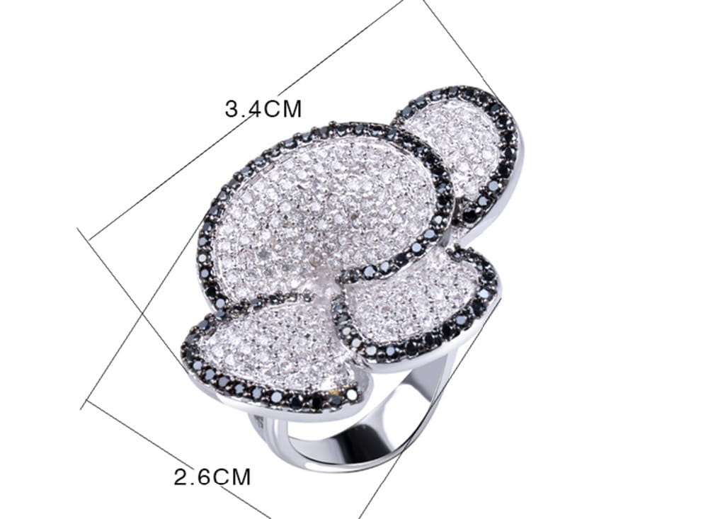 A sparkling silver black and white crystal statement flower ring featuring a four-petal design with pavé-set white and black stones.