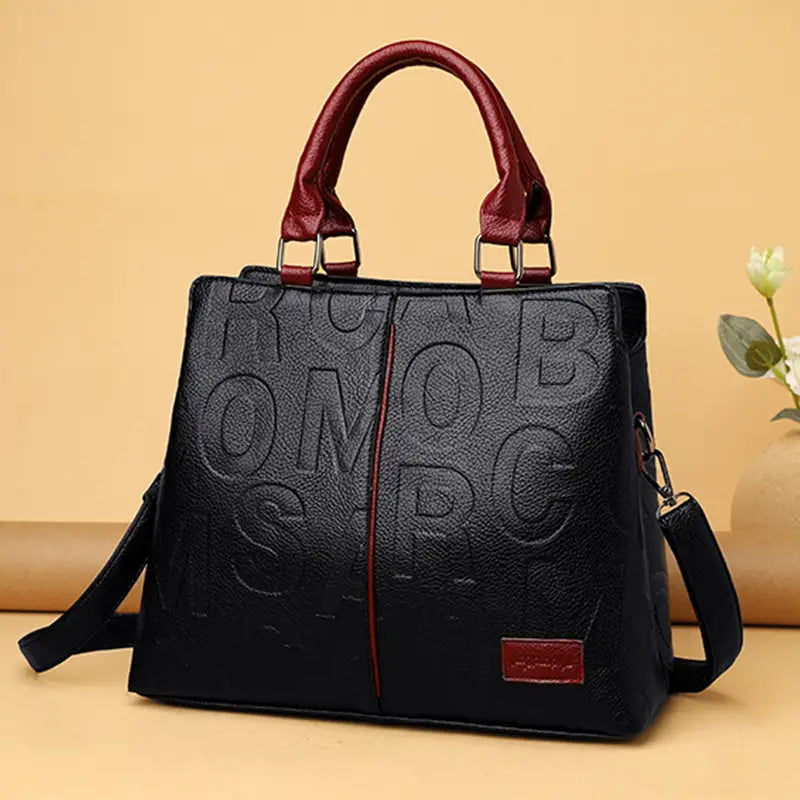 Black crossbody handbag style1 style2 made of black PU leather with embossed lettering and burgundy handles featuring a matching rectangular brand tag.