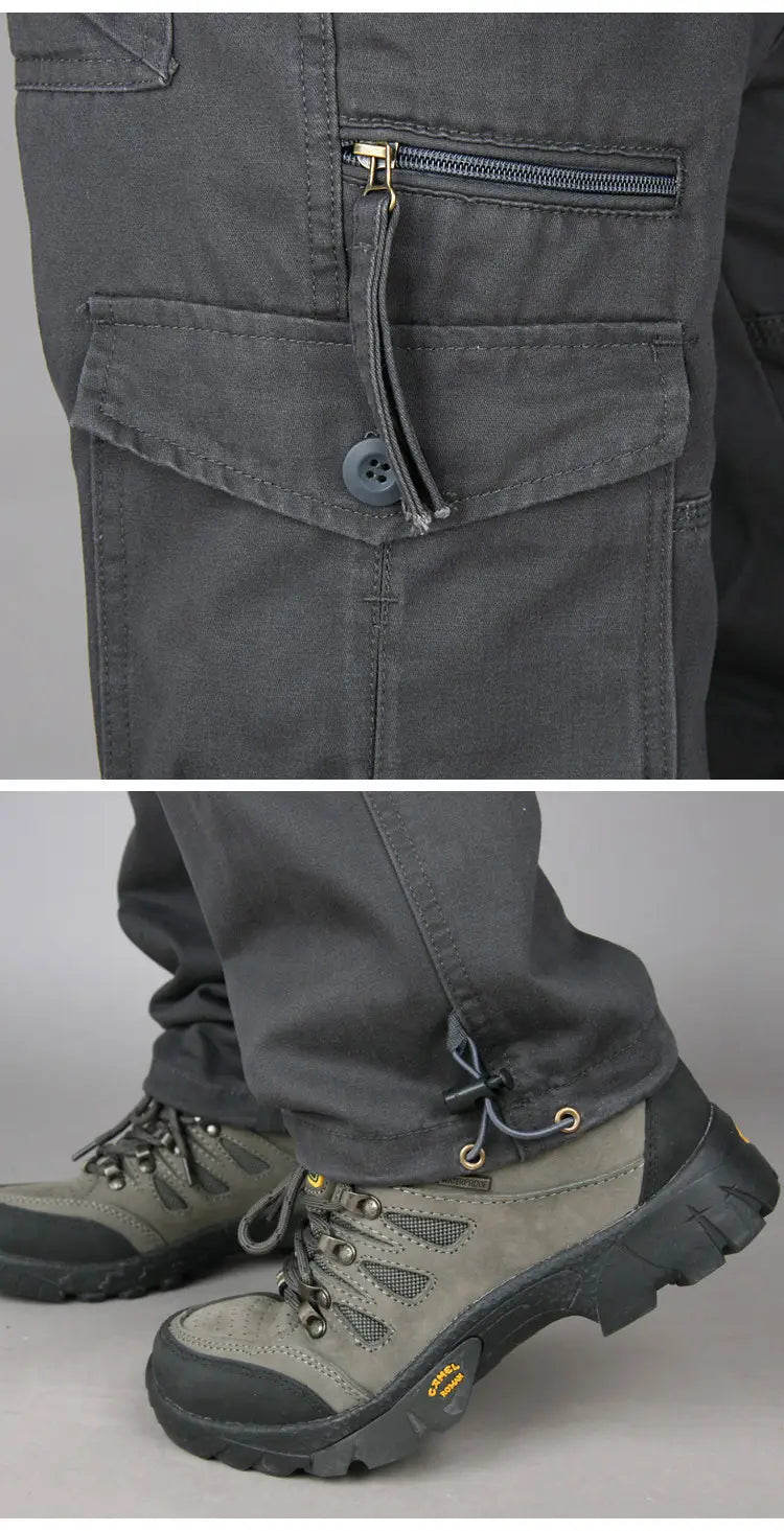 Men tactical cargo pants cotton work trousers in dark gray with multiple pockets and button closure paired with rugged hiking boots.