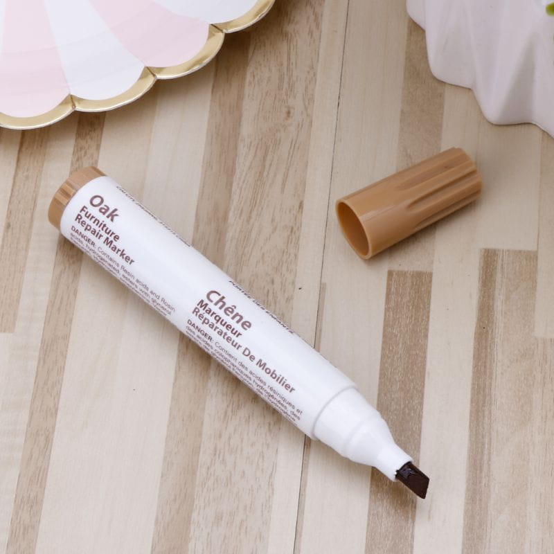 a white oak furniture repair marker with a tan cap and brown tip designed for matching wood stains in a furniture repair marker set with wax sticks