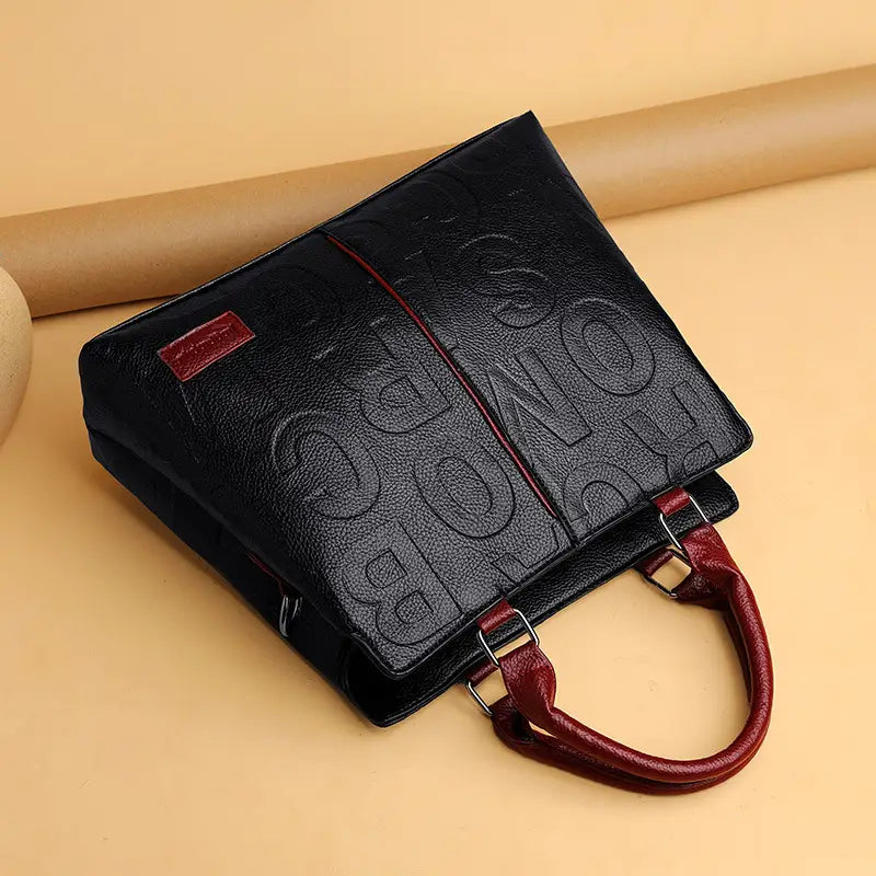 Black crossbody handbag style1 style2 made of black pu leather with embossed lettering and contrasting red handles satchel style1 style2.