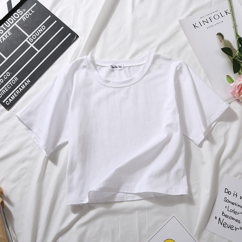 White cropped t-shirt with short sleeves and round neckline made of soft cotton fabric for casual wear.