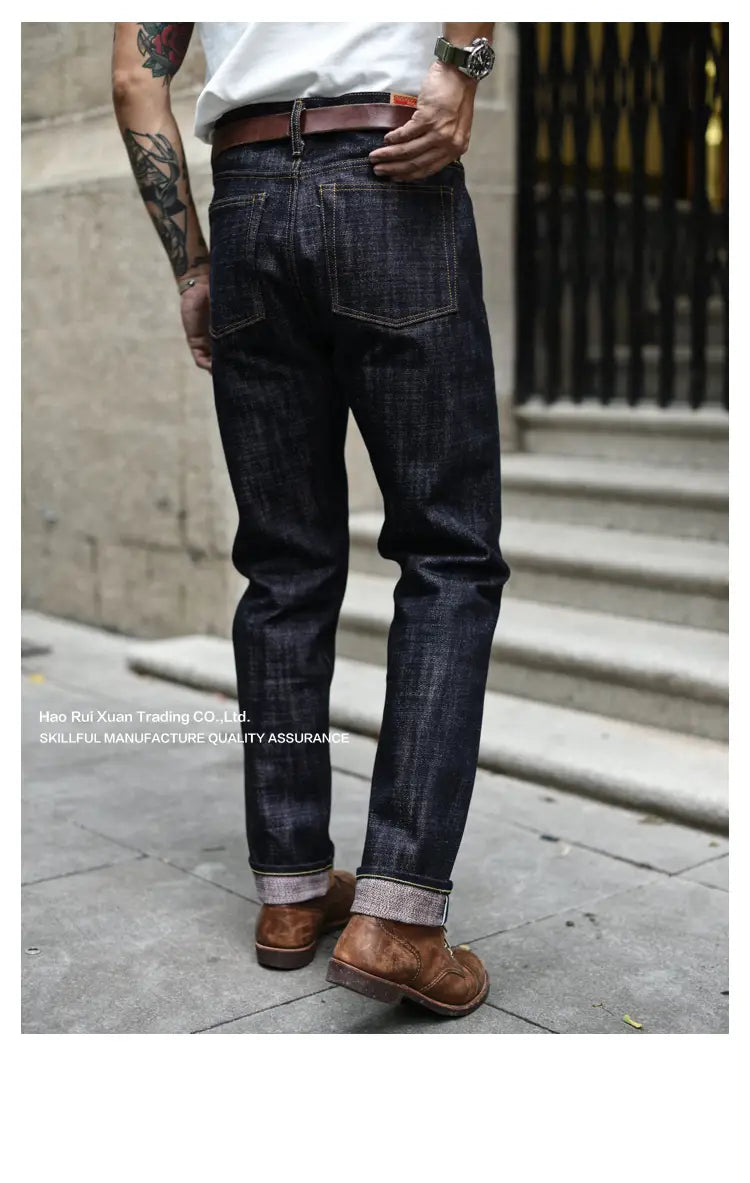 Jean brut conique en selvedge à feu Saucezhan d’un indigo foncé, doté d’un design classique à cinq poches, ainsi que de revers roulés réalisés dans un denim brut résistant.